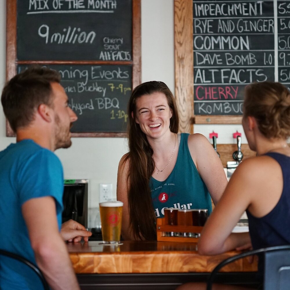 Friends enjoying craft beer at Red Collar Brewing, a Kamloops brewery taproom.
