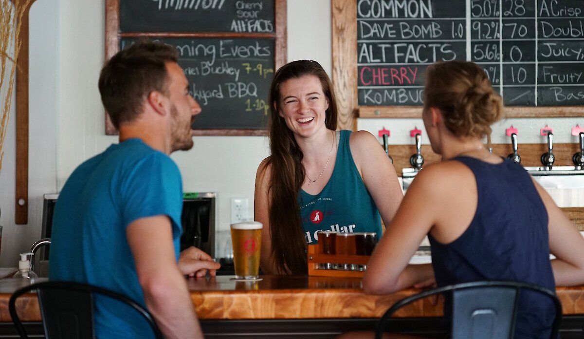 Friends enjoying craft beer at Red Collar Brewing, a Kamloops brewery taproom.