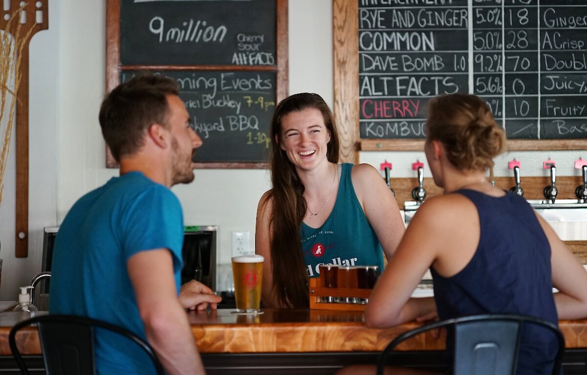 Friends enjoying craft beer at Red Collar Brewing, a Kamloops brewery taproom.