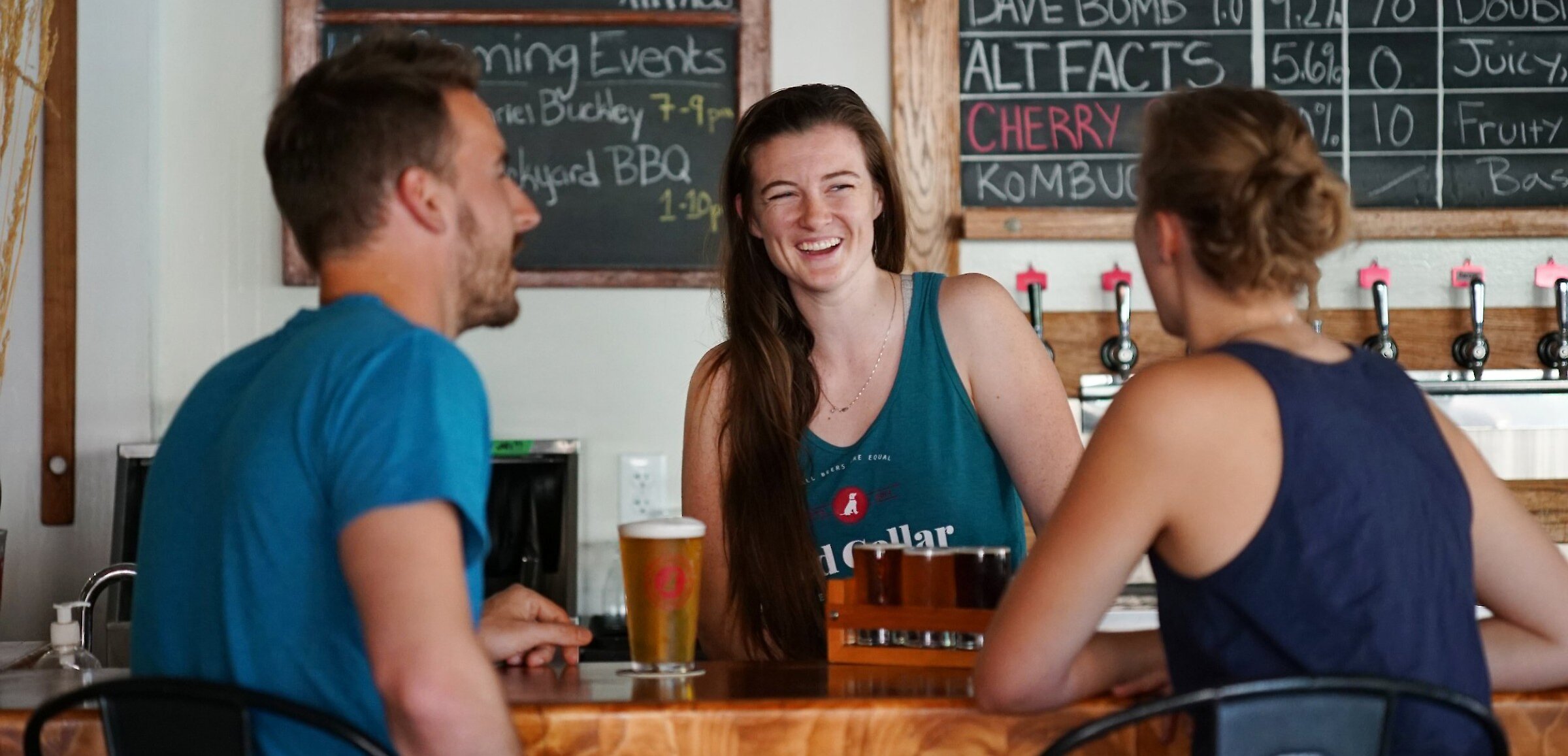 Friends enjoying craft beer at Red Collar Brewing, a Kamloops brewery taproom.