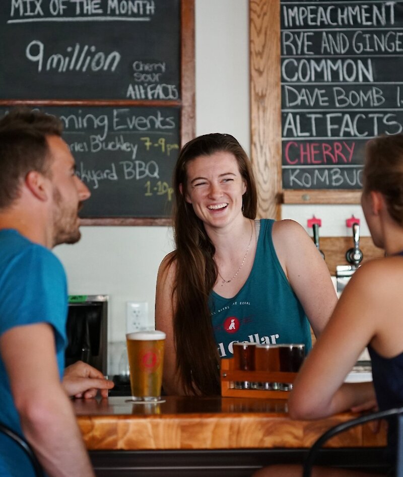 Friends enjoying craft beer at Red Collar Brewing, a Kamloops brewery taproom.