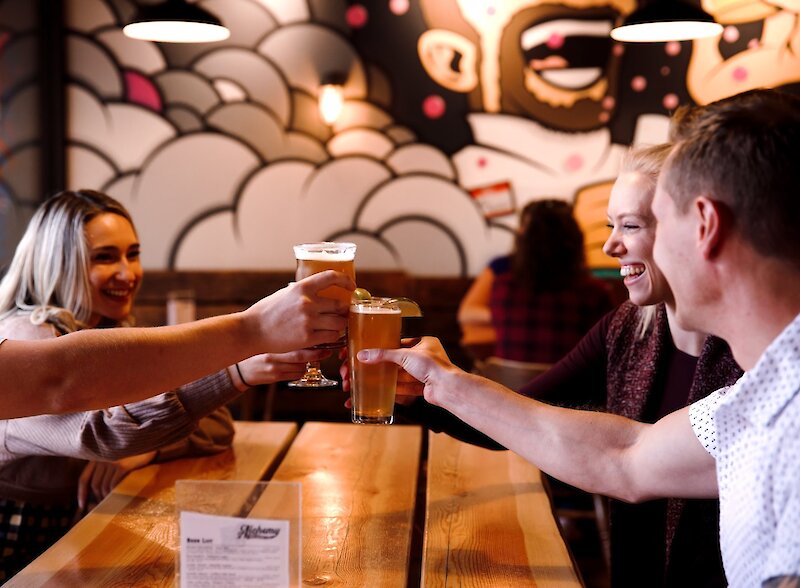 Friends toasting beer at Embers Brewhouse, a Kamloops craft brewery with a laid-back vibe.