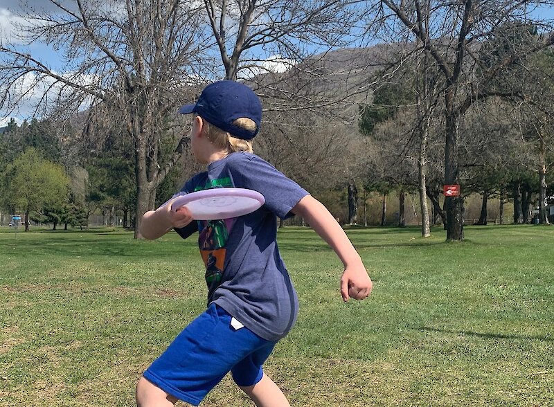 Boy throwing a disc at the Westsyde Centennial Park Disc Golf Course in Kamloops, British Columbia.