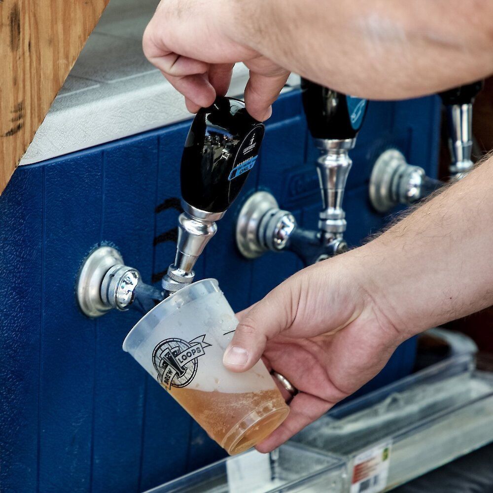 A beer being poured into a Brewloops Festival branded glass.