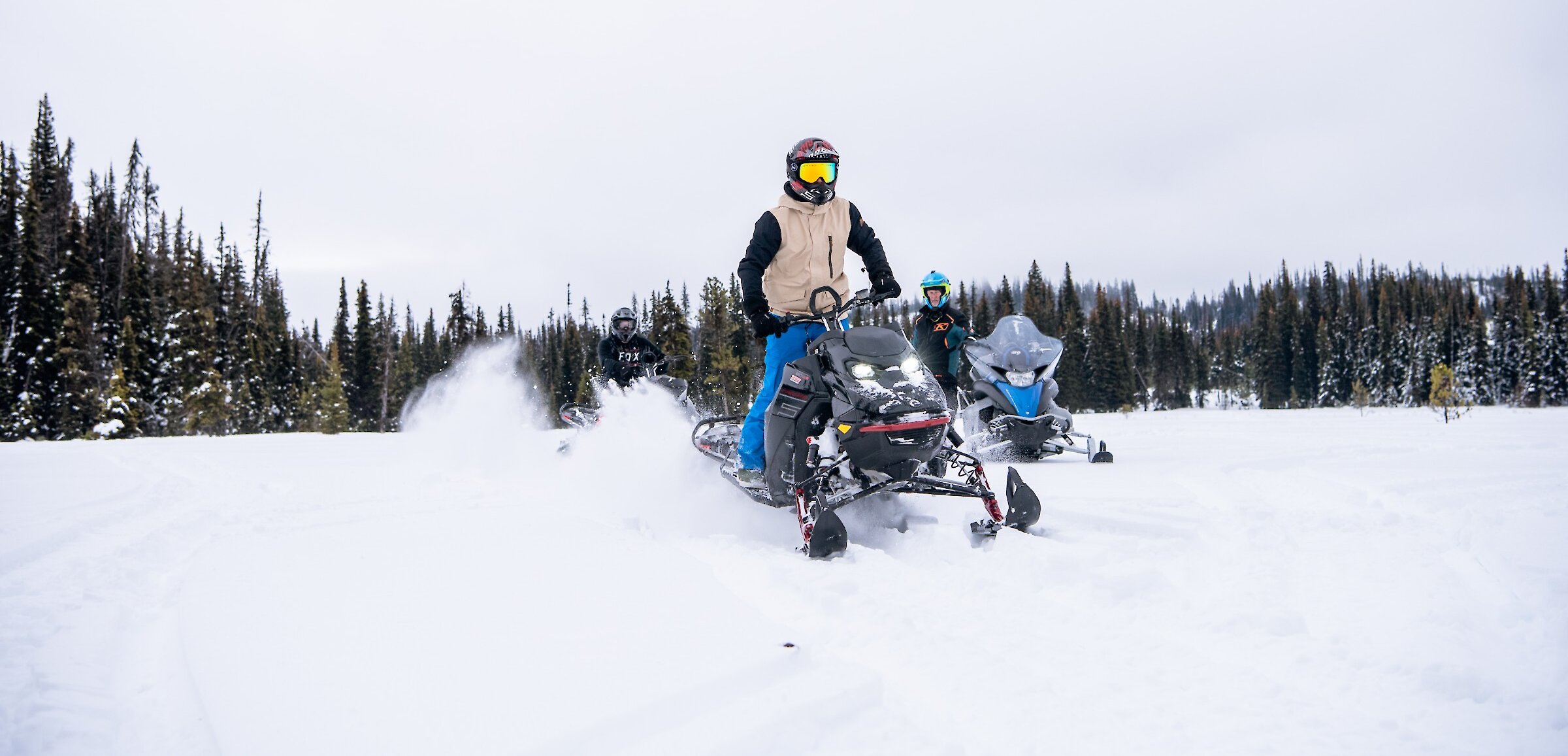 Group of snowmobilers riding through the powdery snow near Kamloops, BC.