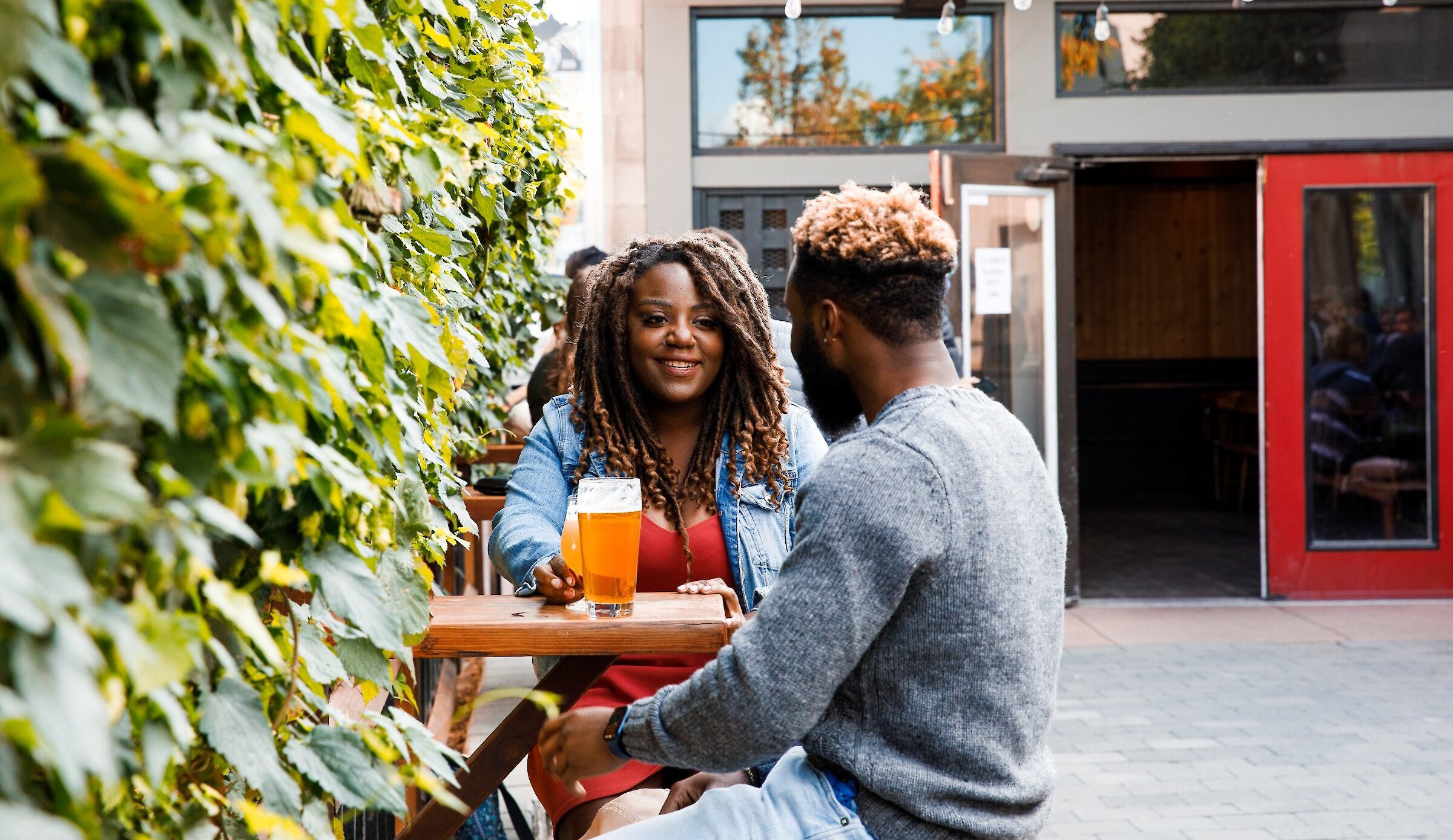 Couple enjoying their local craft beer on the patio at Red Collar Brewing in downtown Kamloops, BC.