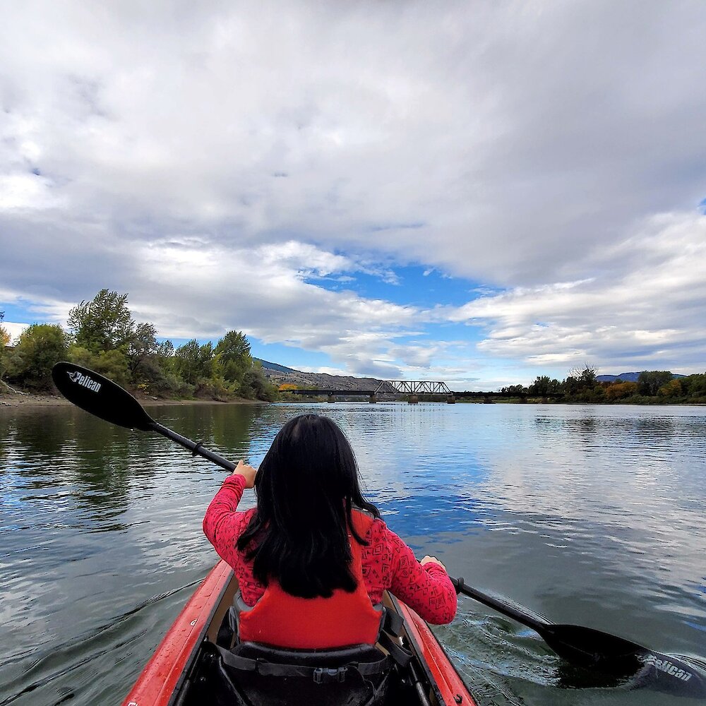 Woman kayaking along the South Thompson River in Kamloops, British Columbia.